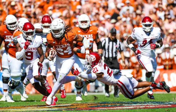 Texas Longhorns running back Jonathon Brooks evades a tackle against a pair of Oklahoma Sooners defenders in the Red River Showdown at the Cotton Bowl in Dallas, Texas.